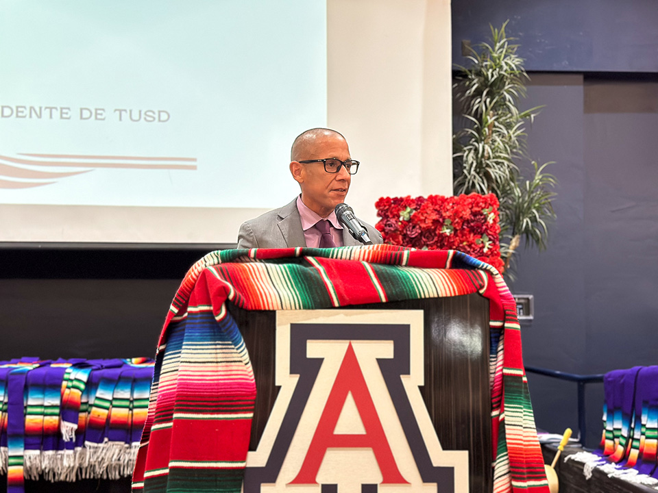 A man speaks to the crowd behind a podium