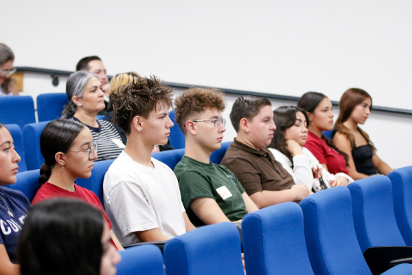Students sitting in an auditorium listen to a presentation
