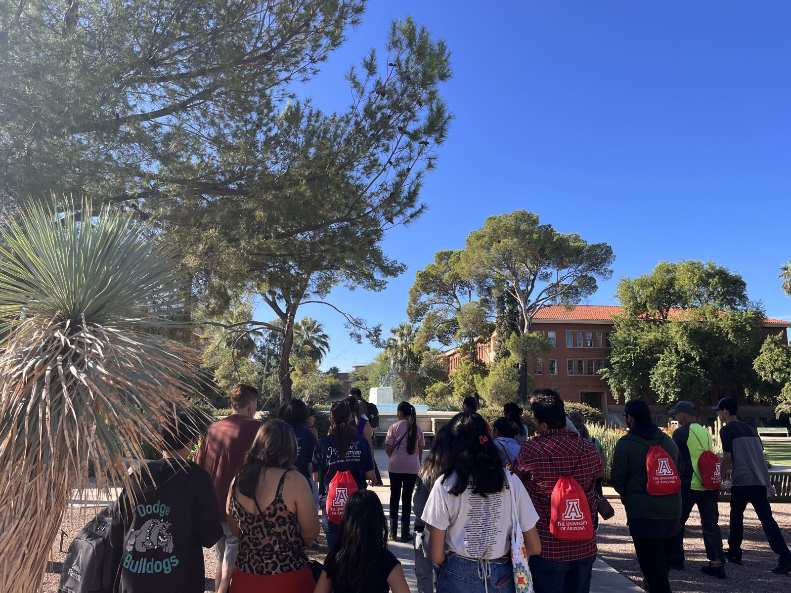 Students gathered around the fount at the university of Arizona old main building. 