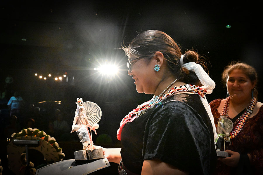 A teen girl smiles at the mic, ready to address the audience