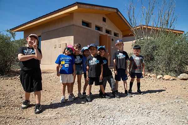Kindergarten students pose outside a cabin at Camp Cooper