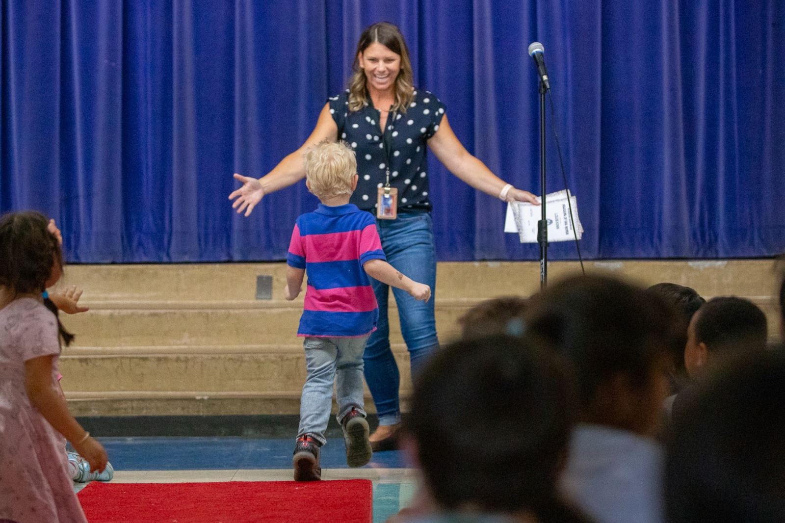 Marshall's principal offers a hug to a student receiving his award