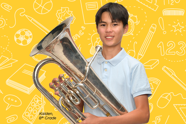 A boy holds a tuba on a yellow background