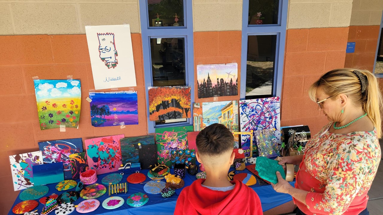 A student and teacher from Mary Meredith K-12 check out student artwork at the Spring Music and Art Festival.