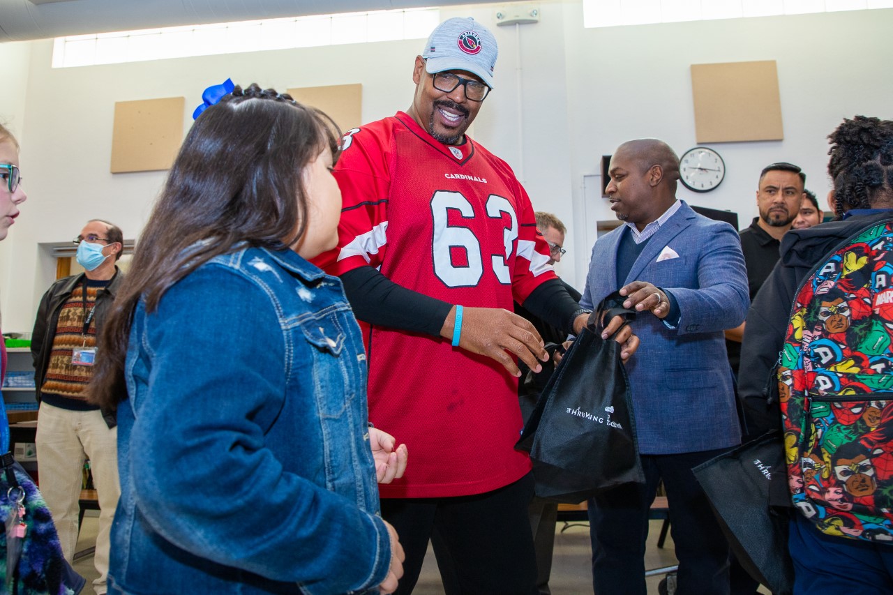 Former Arizona Cardinal Michael Bankston hands out donations from GENYOUth to students at Wright Elementary School.
