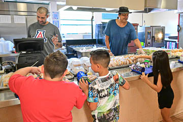 More students fill their trays at the cafeteria.
