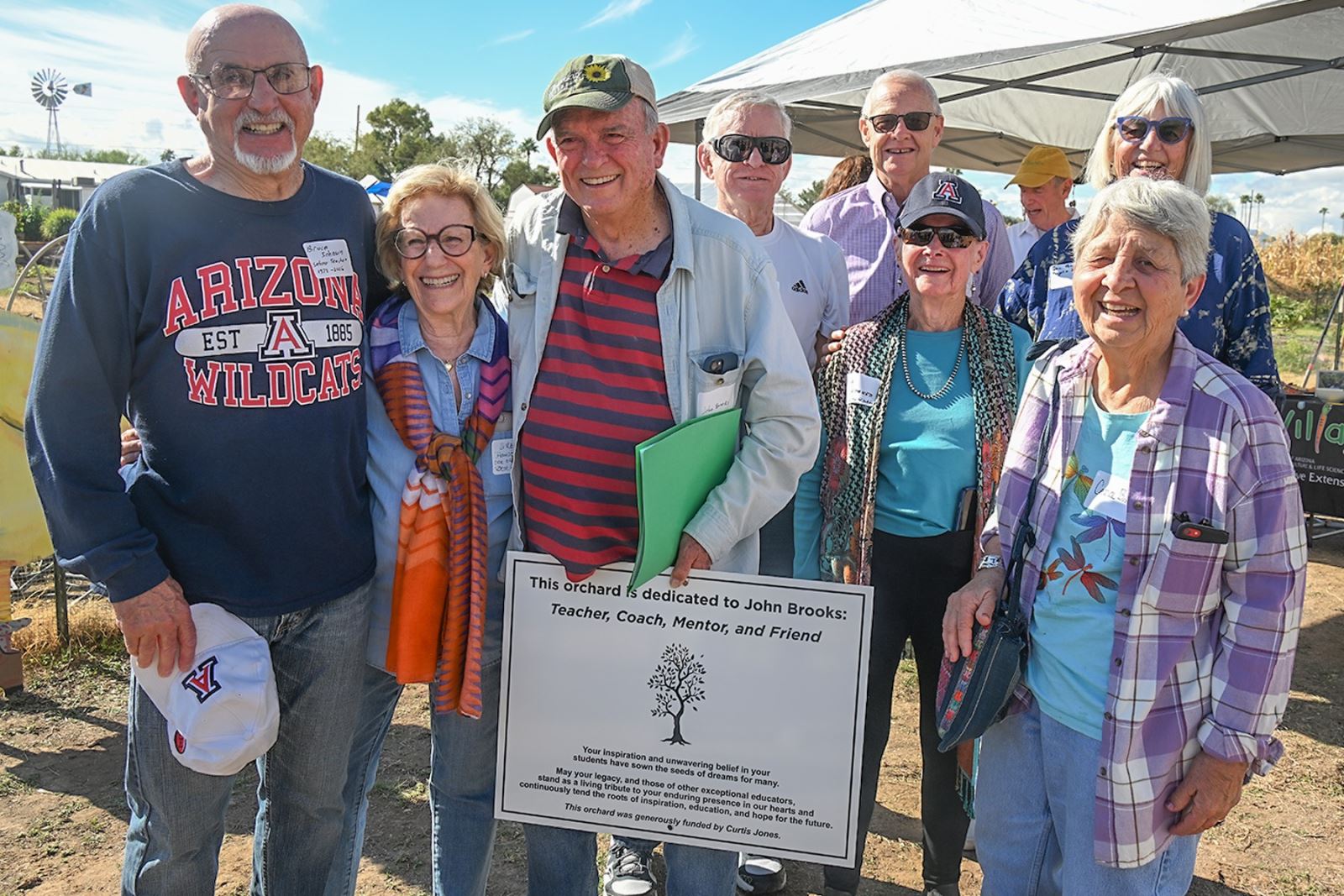 John Brooks smiles with his award at Tucson Village Farm with a group of family and friends.