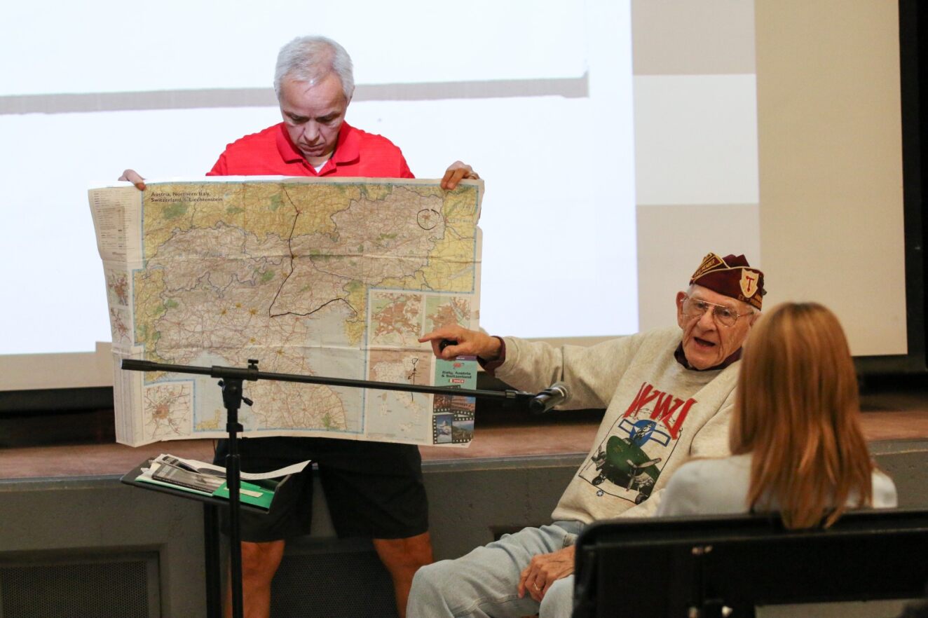 WWII veteran First Officer Harvey Horn shows students on a map where he served during the war.