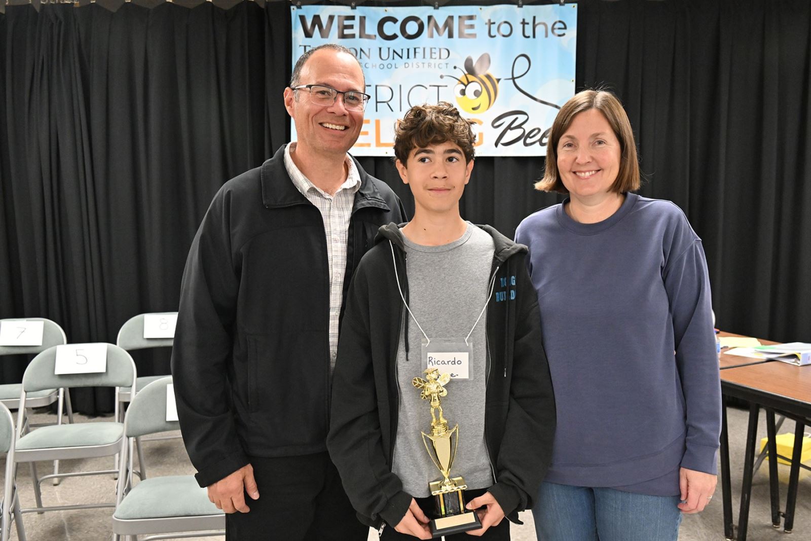 The spelling bee champ poses with his trophy and his parents.