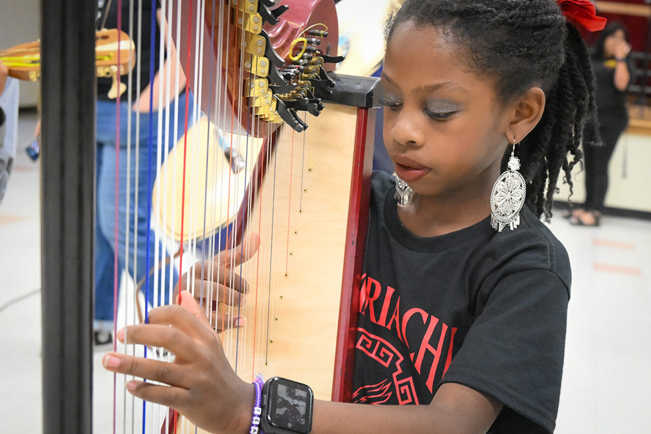 A young girl plays the harp as part of the Davis mariachi.