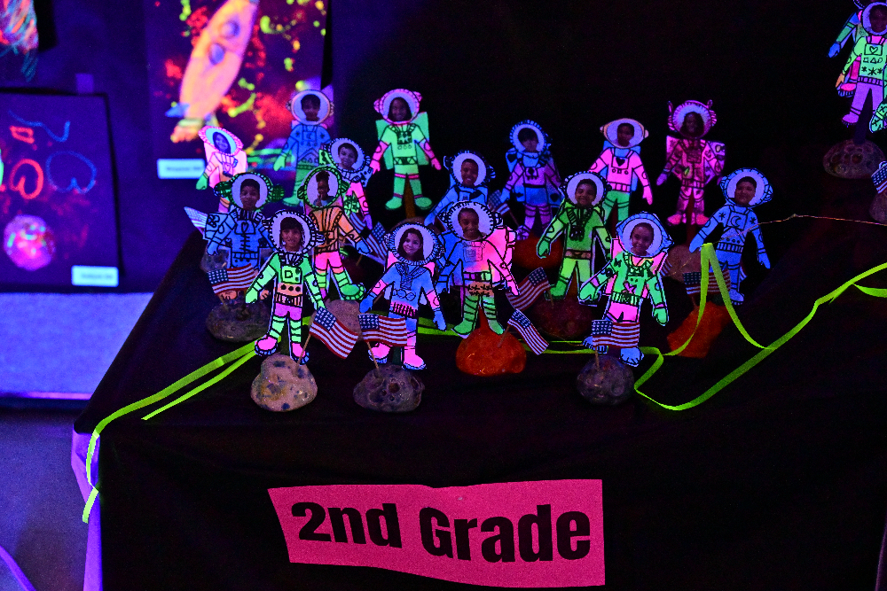 Glow art 2nd grade students as astronauts