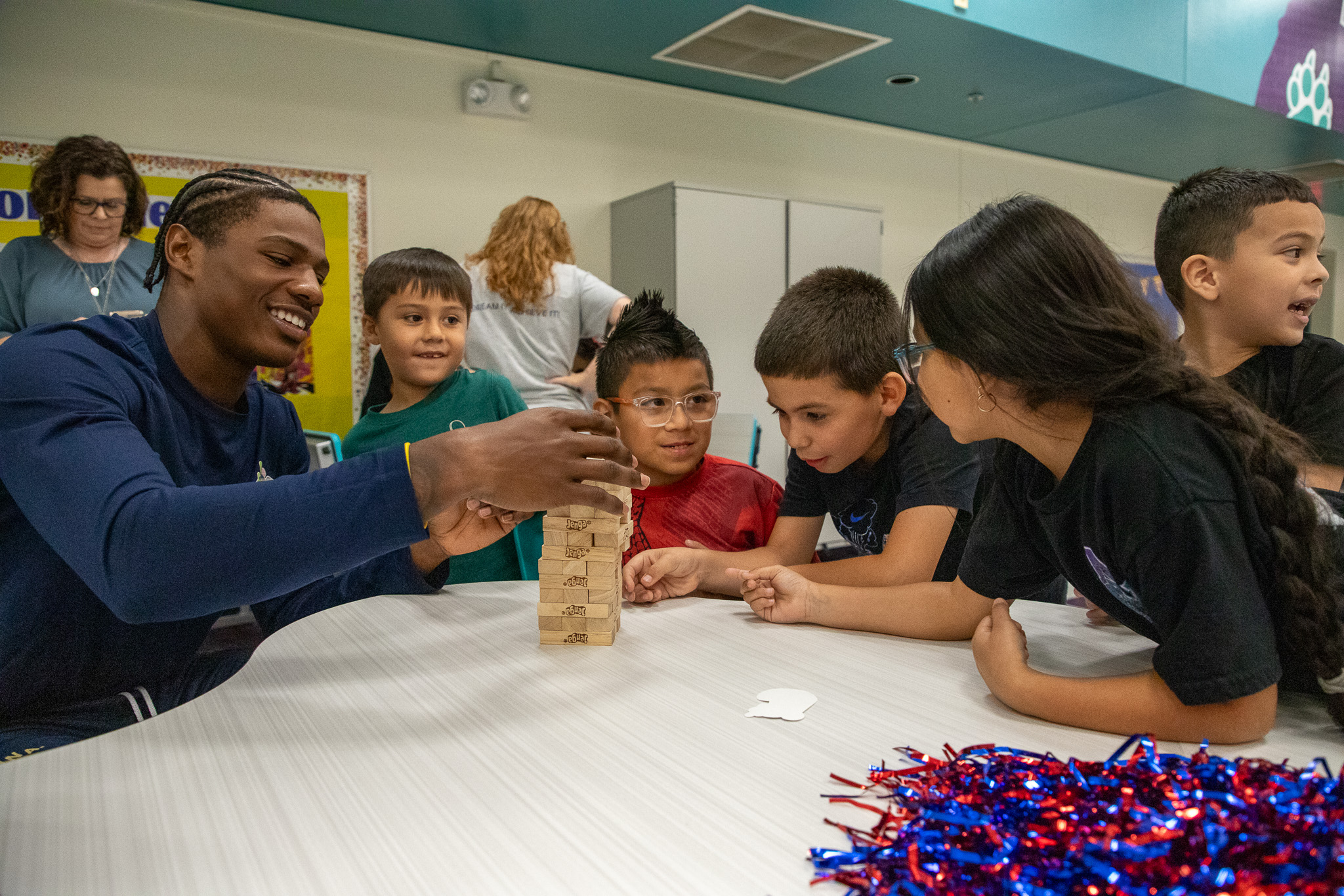 Students gather around a table playing Jenga