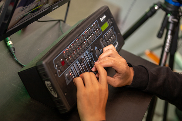 Close up of hands on an audio board