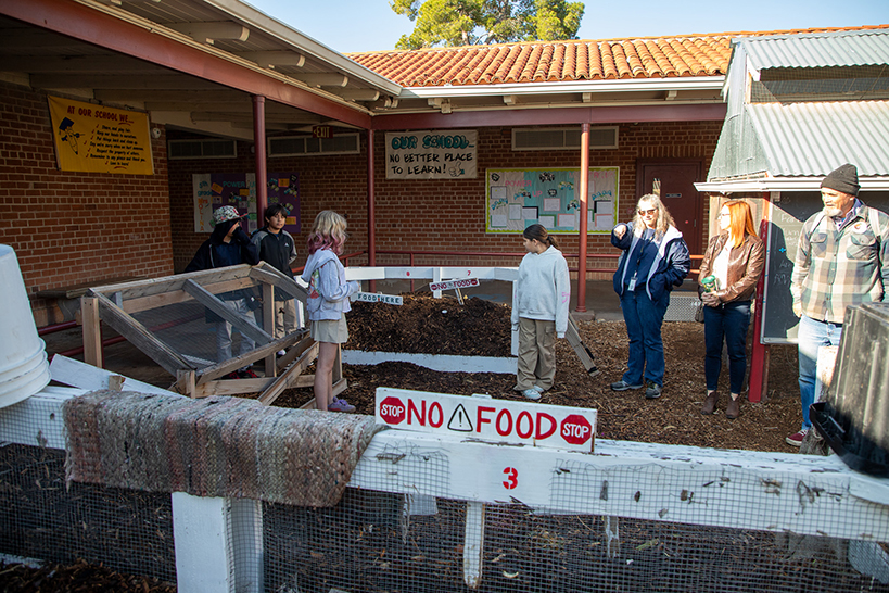 Students and staff stand in the school garden
