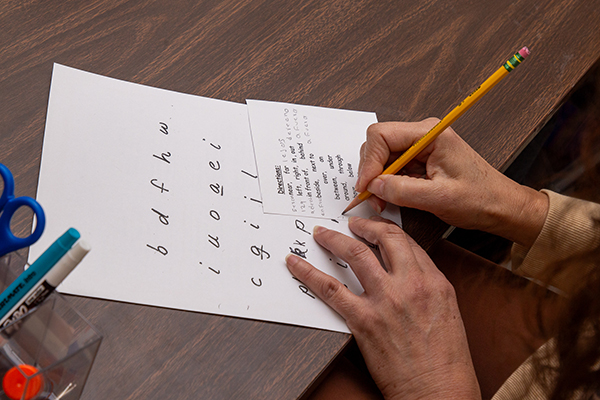 A woman writes on a sheet of paper
