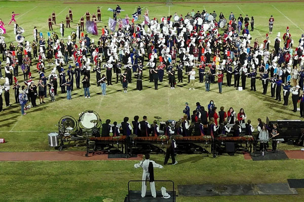 All TUSD high school marching bands performing together on the football field.