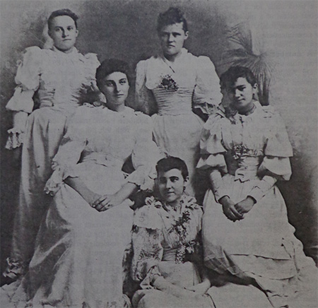 Five young women wearing white dresses for their graduation in 1893.