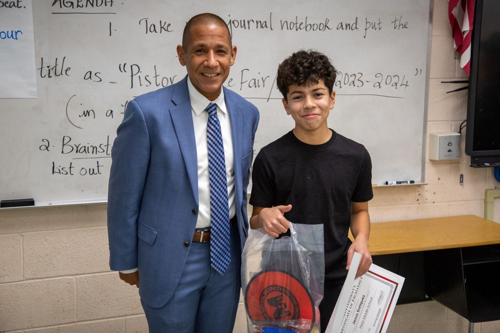 Dr. Trujillo smiles next to one of the students who was awarded the Superintendent's Certificate of Excellence at Pistor Middle School
