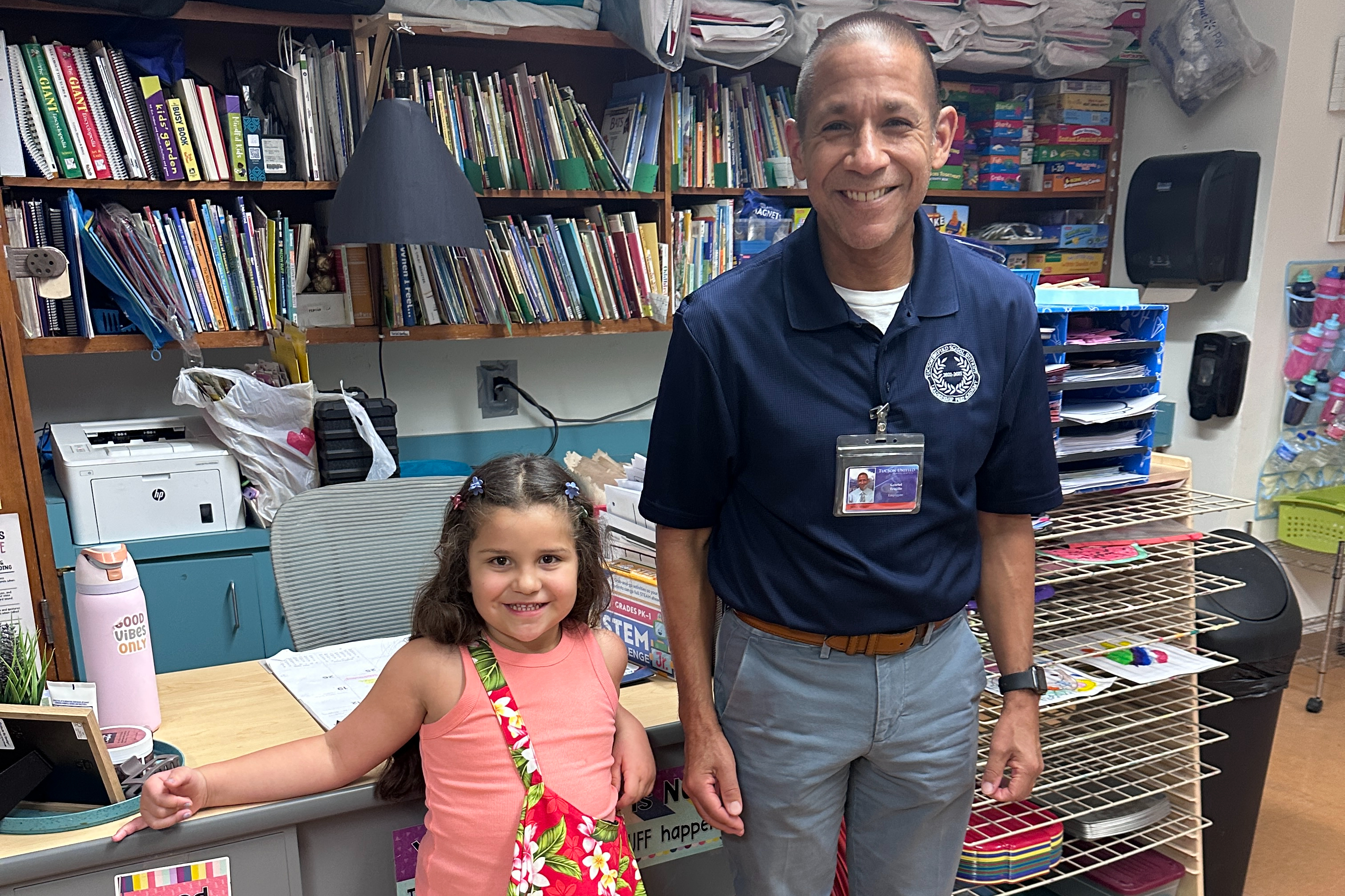 A little girl stands next to the superintendent